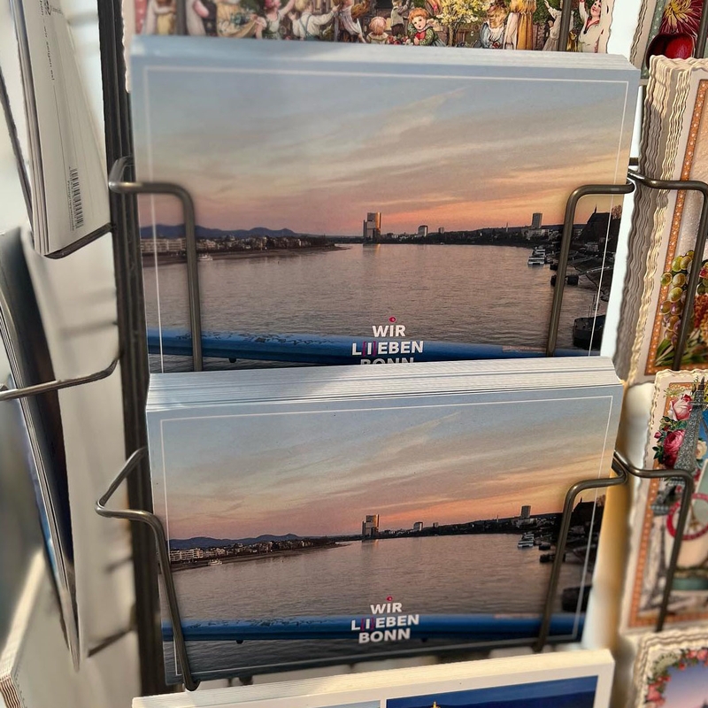 Postkarten der Firma Umweltdruckerei mit Bonn Beuel als Motiv und der Aufschrift, wir L[i]eben Beuel