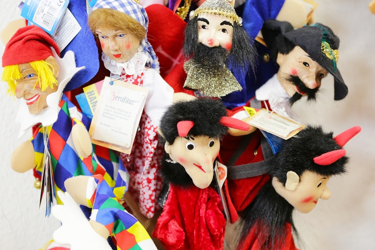 Handpuppen Eine Auswahl von Handpuppen in verschiedenen Ausführungen. Unter anderem sind ein Narr, ein Jäger und zwei Teufel zu sehen.
